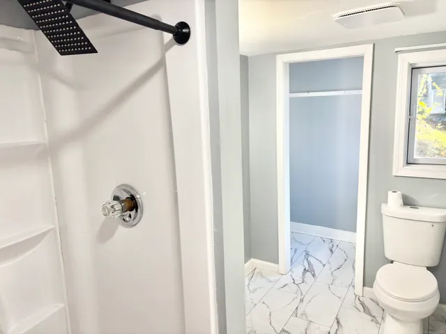 a bathroom with a toilet sink and shower