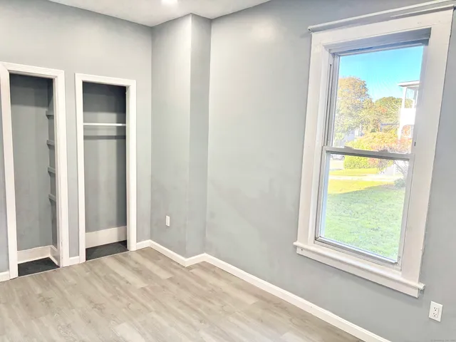a view of an empty room with window and closet area