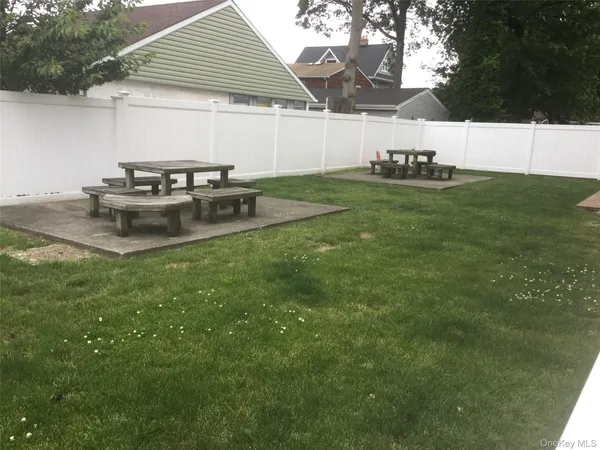 a view of a backyard with table and chairs under an umbrella
