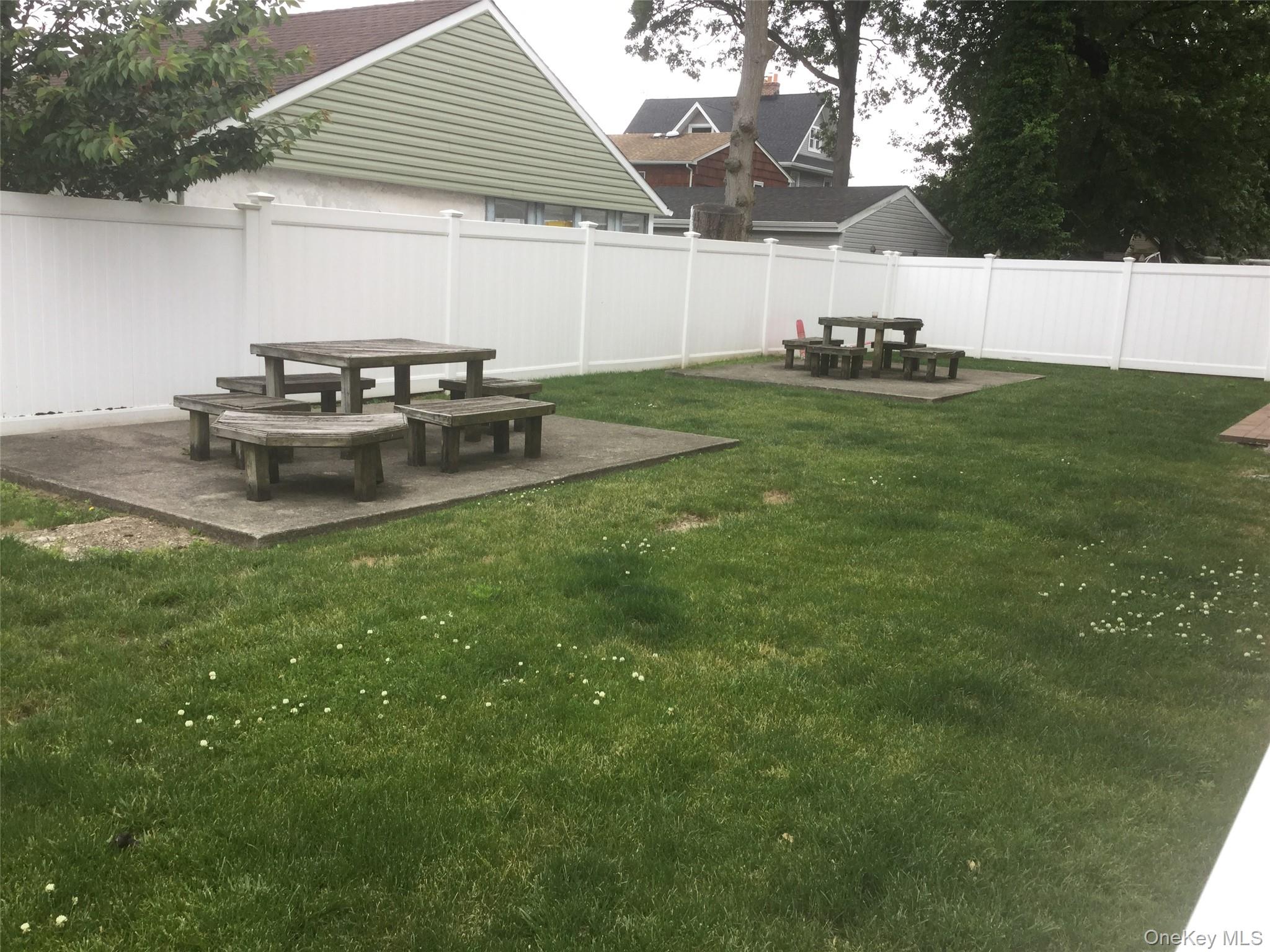 51 Smith Street, Unit B5 Merrick, NY 11566 - Photo 4 of 8 a view of a backyard with table and chairs under an umbrella