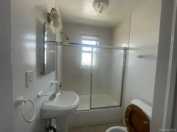 a bathroom with a sink mirror and toilet