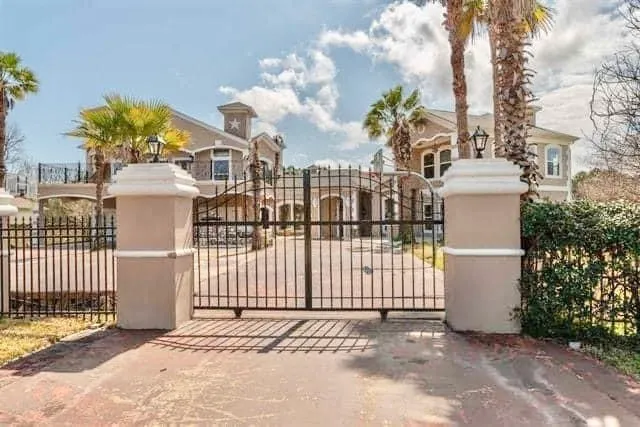 a view of a white house with wooden fence