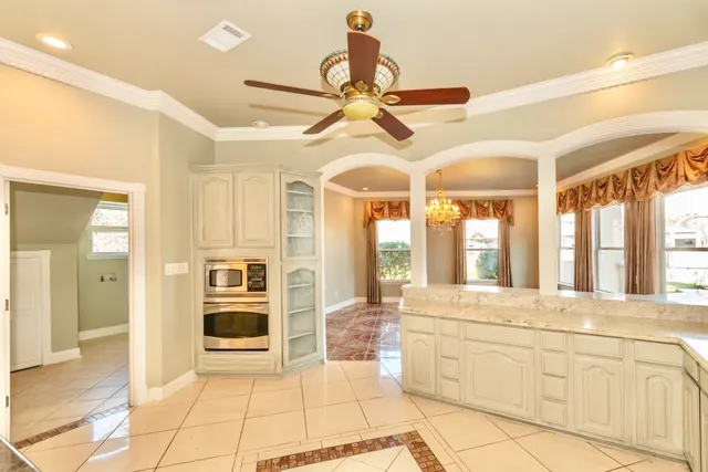 a kitchen with stainless steel appliances granite countertop a stove and white cabinets with wooden floor