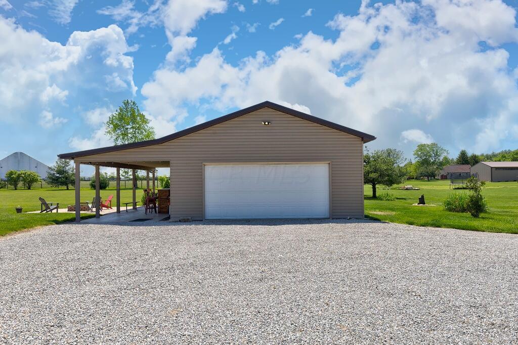 1300 Hubbard Road Galloway, OH 43119 - Photo 52 of 89 • 4 Car tandem • 2 Car carport • Concrete floor • Craftsman® electric door opener • Wall cabinets • Partially finished walls & ceiling • Wall shelves • Barn door & man door • Pegboard wall • Lighted ceiling fan • Fluorescent lighting • New vinyl siding ~ 2019 • New windows ~ 2019 • Separate electric panel