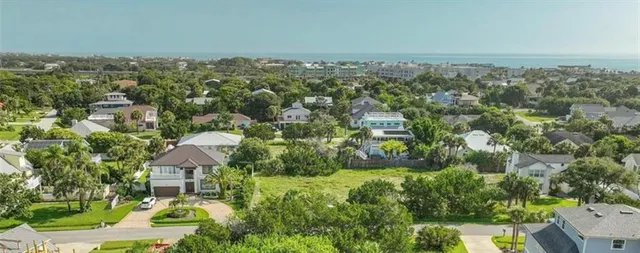 an aerial view of residential house with outdoor space and trees all around