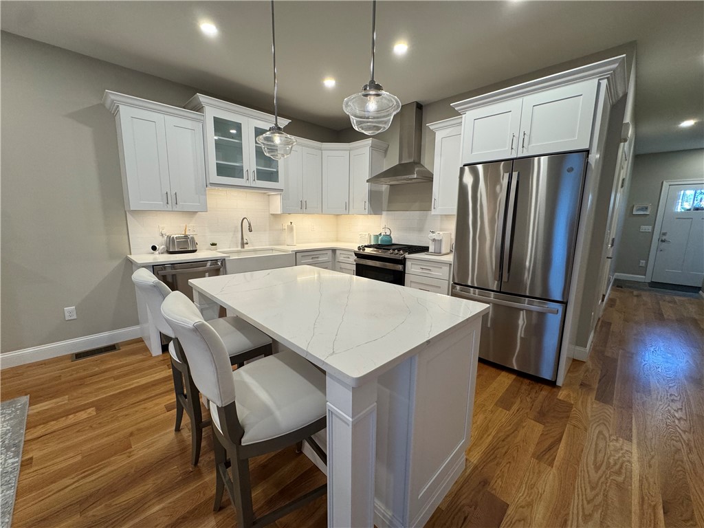 25 Franklin Road, Unit 1 East Greenwich, RI 02818 - Photo 6 of 38 A designer centerpiece, the island boasts polished quartz countertops and bar seating for two, while the kitchen features stainless steel appliances, a gas stove and plenty of counterspace and lighting.