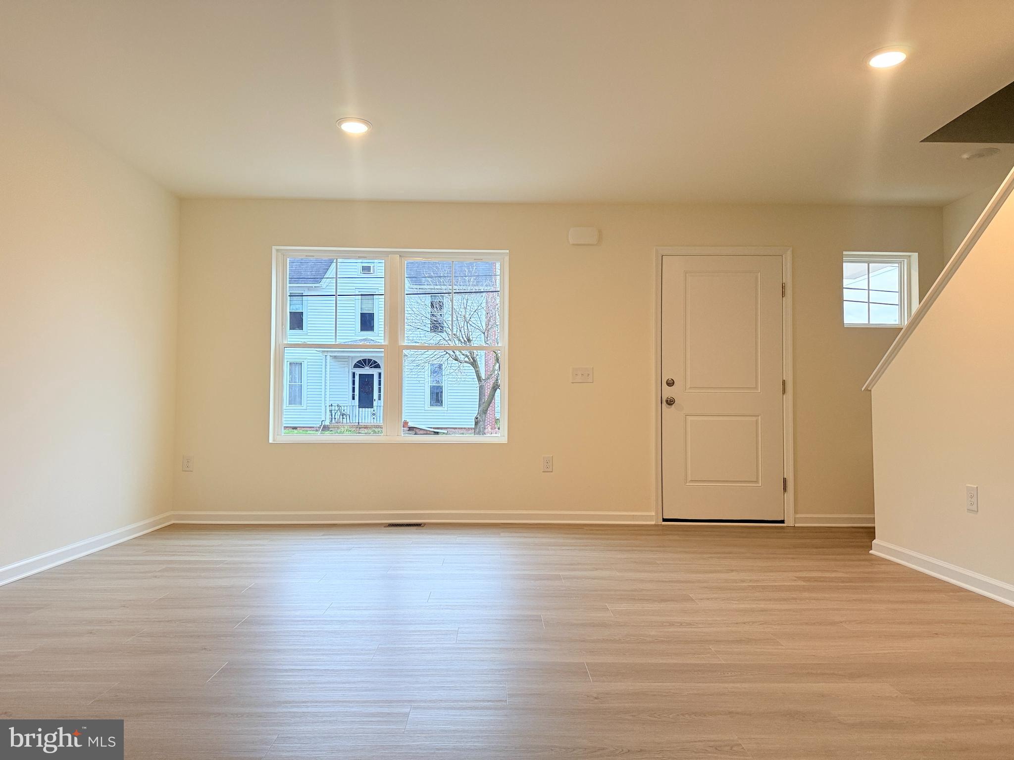 400 North Walnut Street Milford, DE 19963 - Photo 3 of 12 an empty room with wooden floor and windows