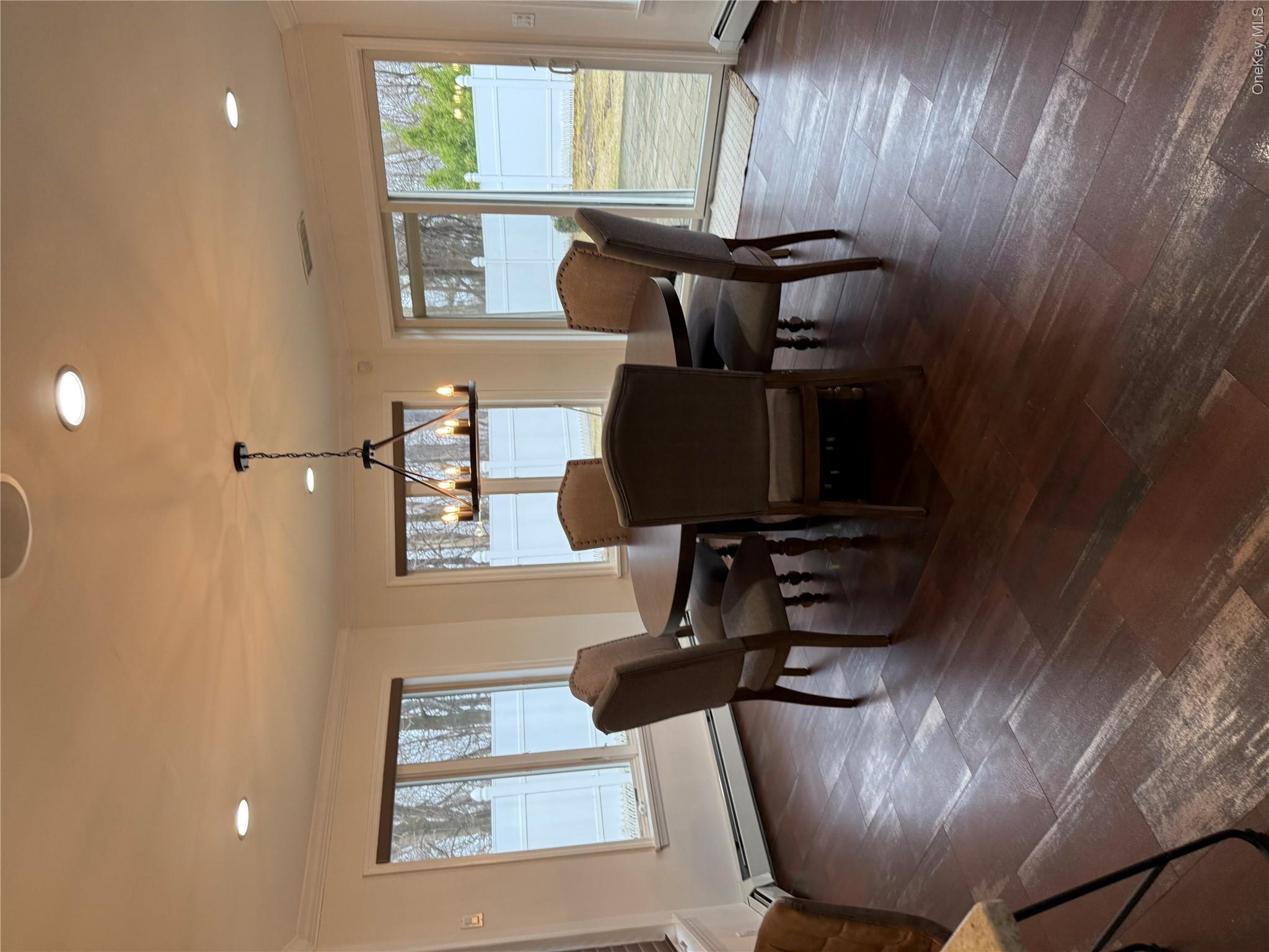 29 Wilton Road Rye Brook, NY 10573 - Photo 11 of 18 Dining space featuring a notable chandelier, dark wood-style floors, baseboard heating, and ornamental molding