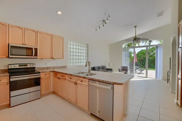 a kitchen with stainless steel appliances granite countertop a stove a sink and a microwave