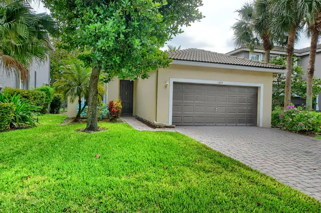 a front view of a house with a yard and garage
