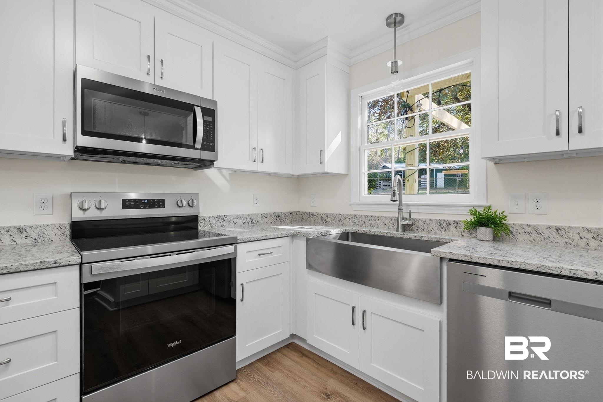 814 Nassau Drive Mobile, AL 36608 - Photo 3 of 44 Kitchen with stainless steel appliances, crown molding, white cabinets, light stone counters, and pendant lighting