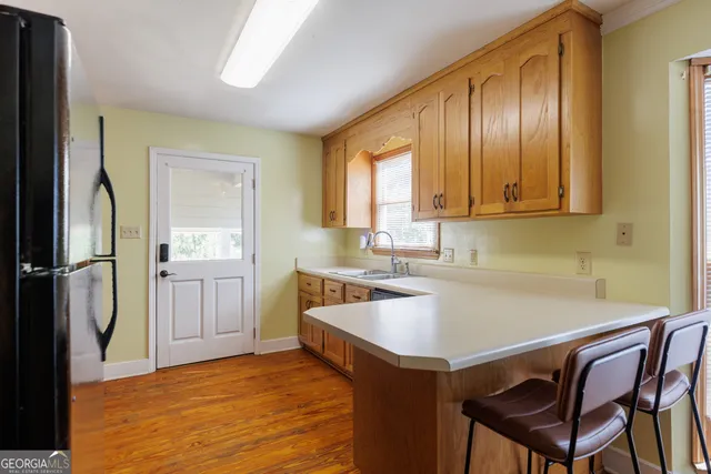 a kitchen with a sink cabinets and wooden floor
