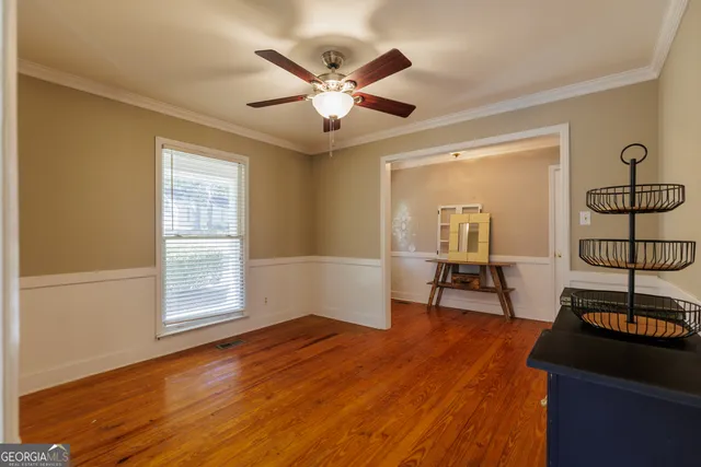 a view of an empty room with a window and wooden floor
