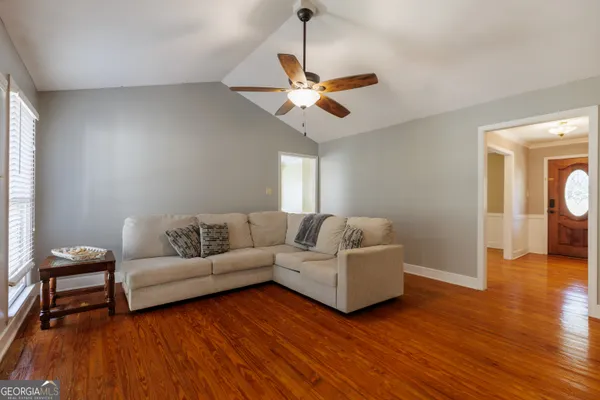 a living room with furniture and a wooden floor
