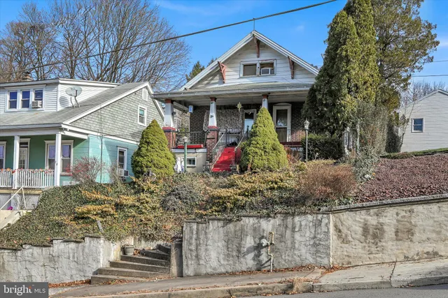 a view of a white house with large windows and a small yard
