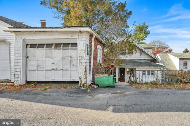 a view of a white house with large windows and a small yard