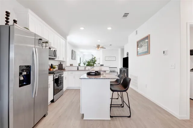 a kitchen with stainless steel appliances kitchen island a refrigerator and a stove