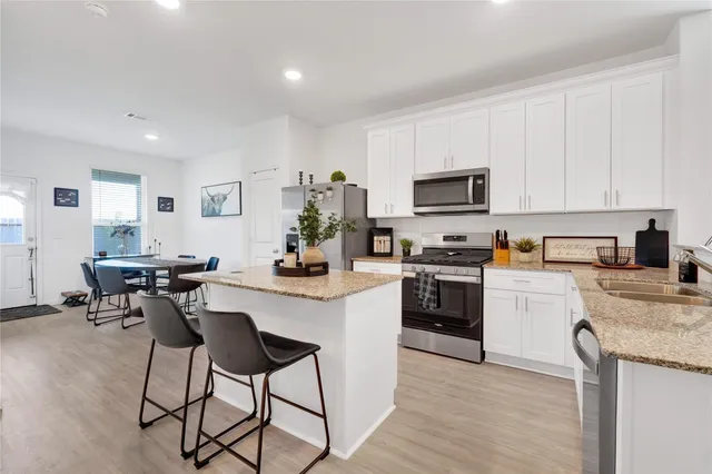 a kitchen with white cabinets and black appliances