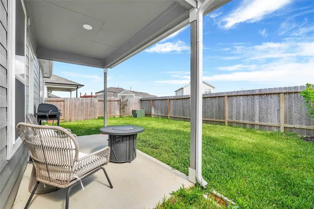 a view of a chair and table in backyard of the house
