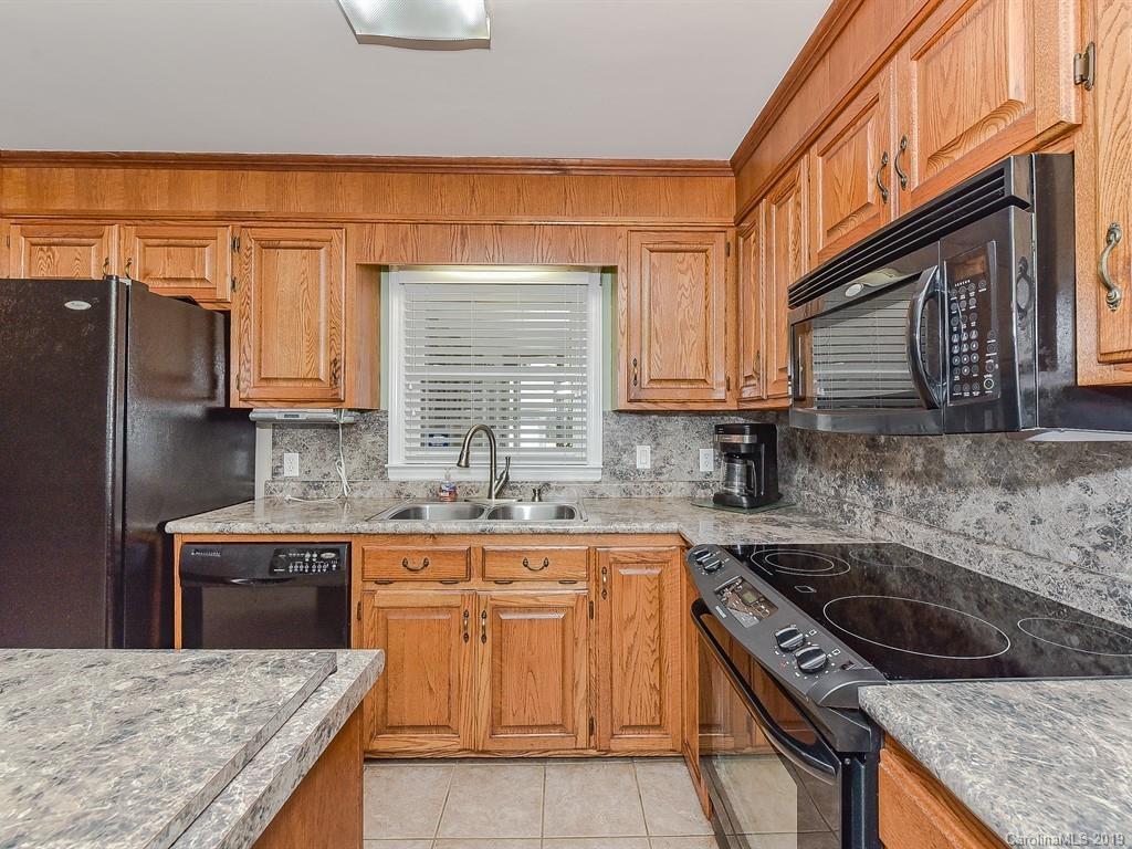 507 Sikes Mill Road Monroe, NC 28110 - Photo 13 of 40 a kitchen with granite countertop a sink stove and cabinets