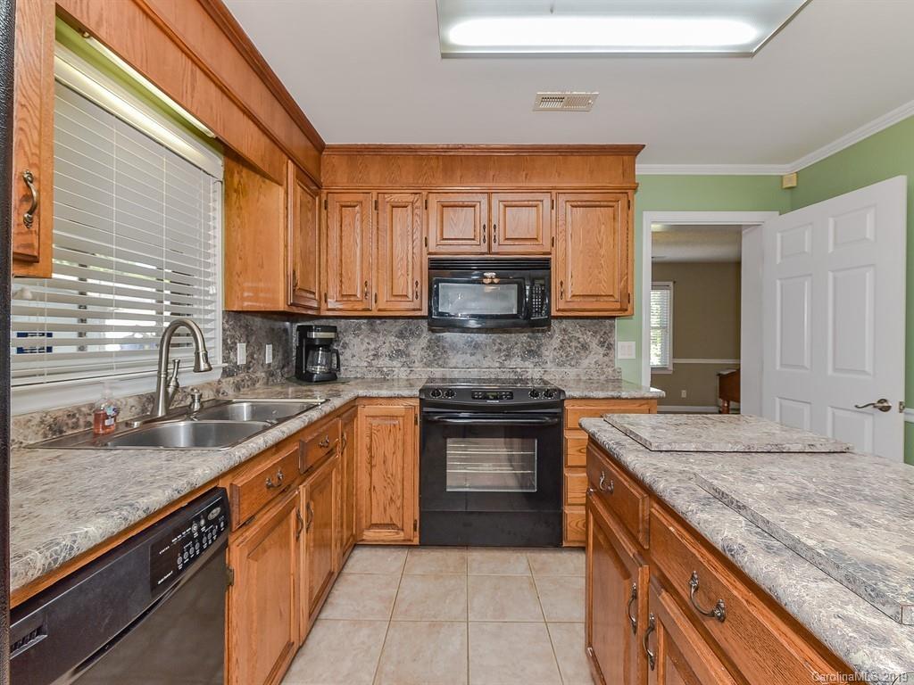 507 Sikes Mill Road Monroe, NC 28110 - Photo 14 of 40 a kitchen with stainless steel appliances granite countertop a sink stove and cabinets