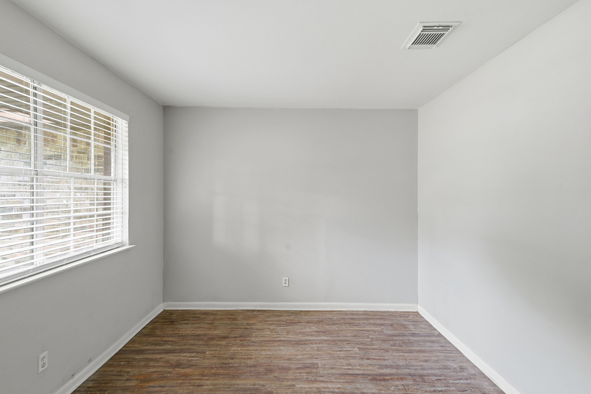 6410 Hopper Road Houston, TX 77016 - Photo 8 of 28 a view of an empty room with wooden floor and a window