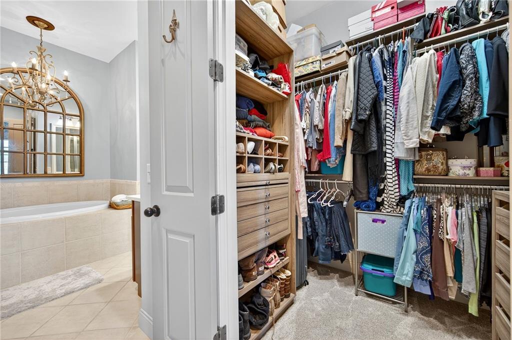 360 Chambers Street, Unit 402 Woodstock, GA 30188 - Photo 22 of 37 a view of walk in closet with clothes and shoes