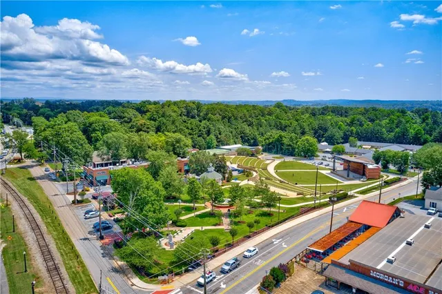 an aerial view of residential houses with outdoor space and trees