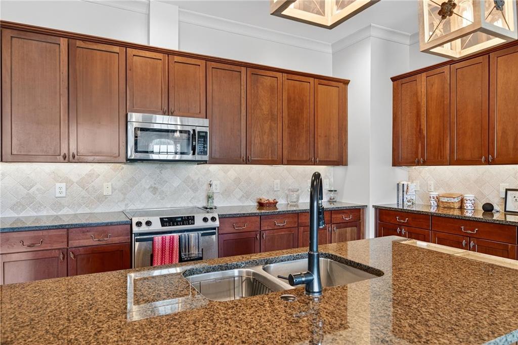 360 Chambers Street, Unit 402 Woodstock, GA 30188 - Photo 10 of 37 a kitchen with stainless steel appliances granite countertop a sink a stove microwave and cabinets
