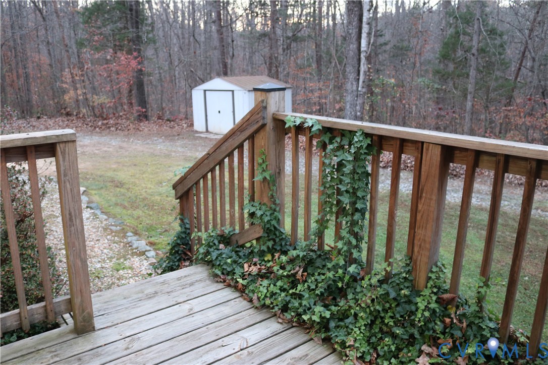 128 Quarry Road Cumberland, VA 23040 - Photo 27 of 36 Deck featuring a view of trees, a storage unit, an