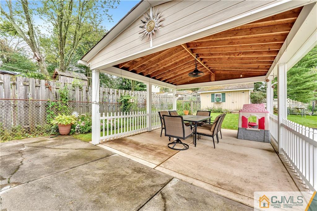 121 Highfield Road Colonia, NJ 07067 - Photo 19 of 23 a view of a patio with table and chairs with wooden floor and fence