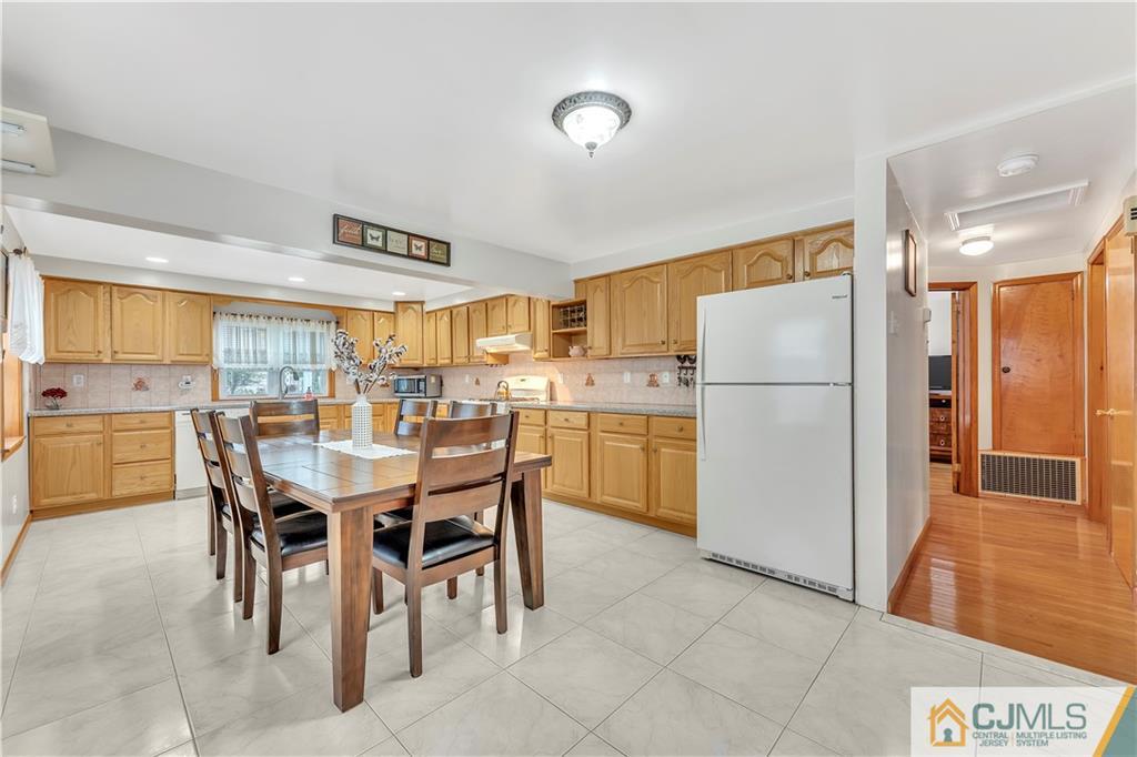 121 Highfield Road Colonia, NJ 07067 - Photo 8 of 23 a kitchen with a refrigerator a table and chairs