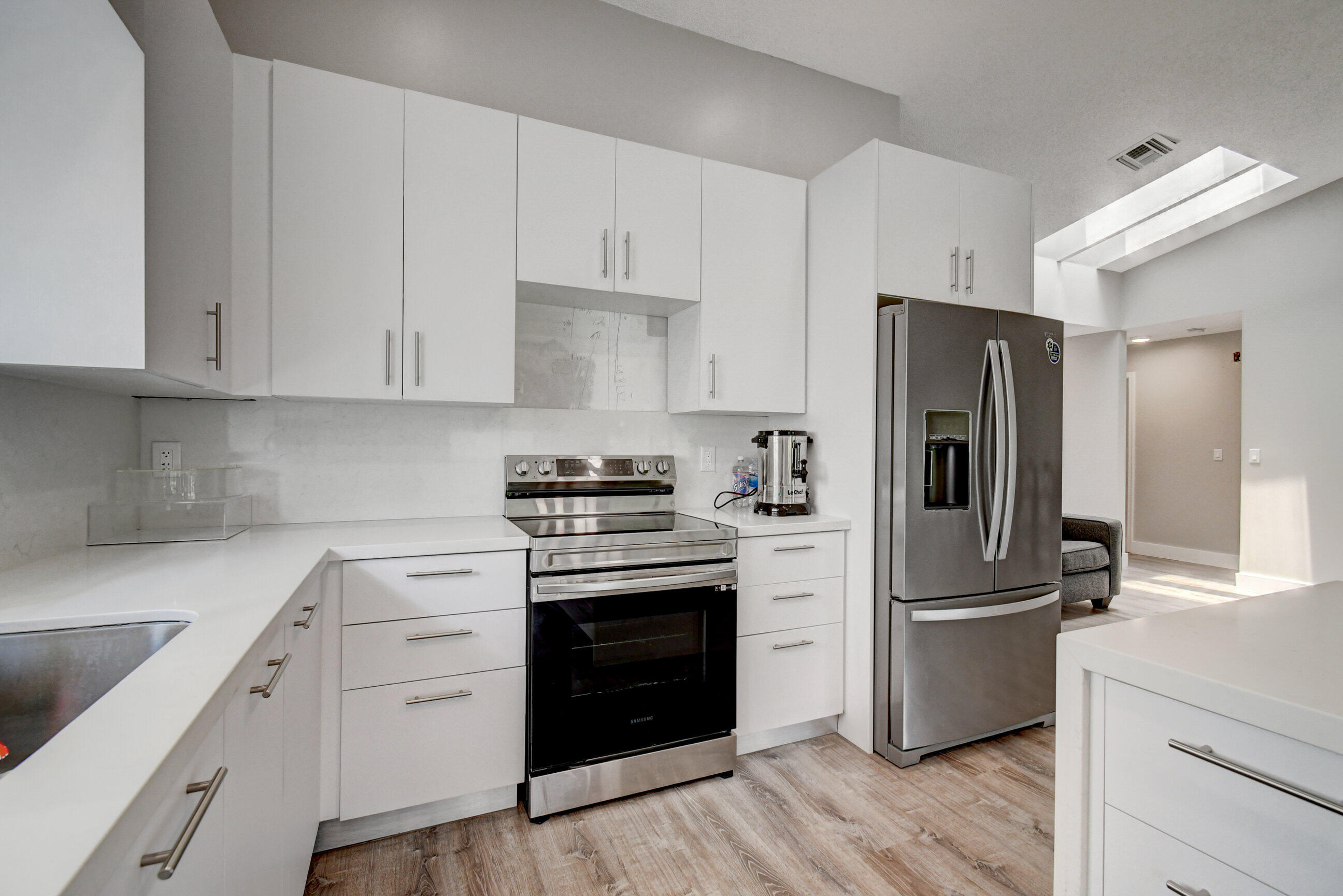 7582 Solimar Circle Boca Raton, FL 33433 - Photo 1 of 28 a kitchen with a refrigerator stove and white cabinets