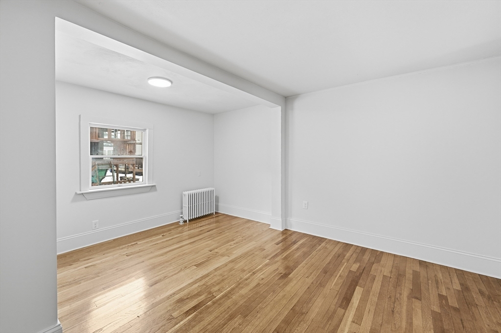 22 Douglas Avenue, Unit 1 Maynard, MA 01754 - Photo 12 of 19 a view of an empty room with wooden floor and a window