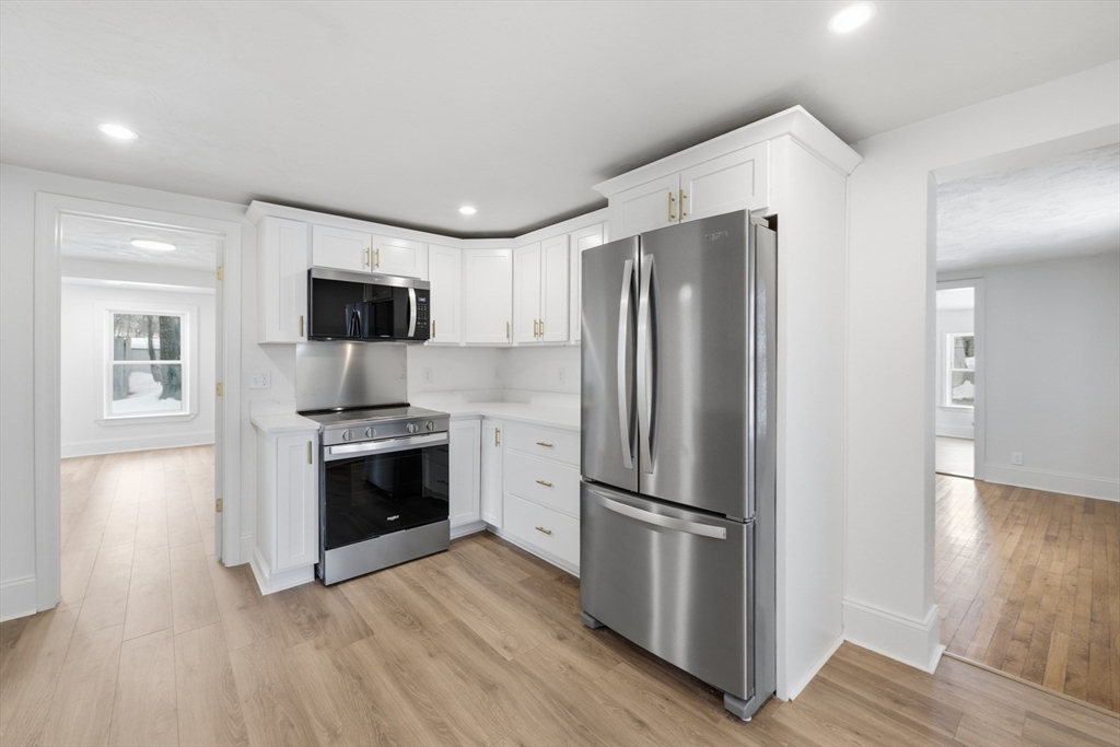 22 Douglas Avenue, Unit 1 Maynard, MA 01754 - Photo 14 of 19 a kitchen with stainless steel appliances a refrigerator stove and microwave