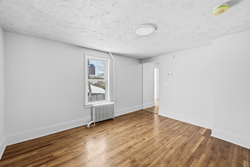 22 Douglas Avenue, Unit 1 Maynard, MA 01754 - Photo 17 of 19 a view of an empty room with wooden floor and a window