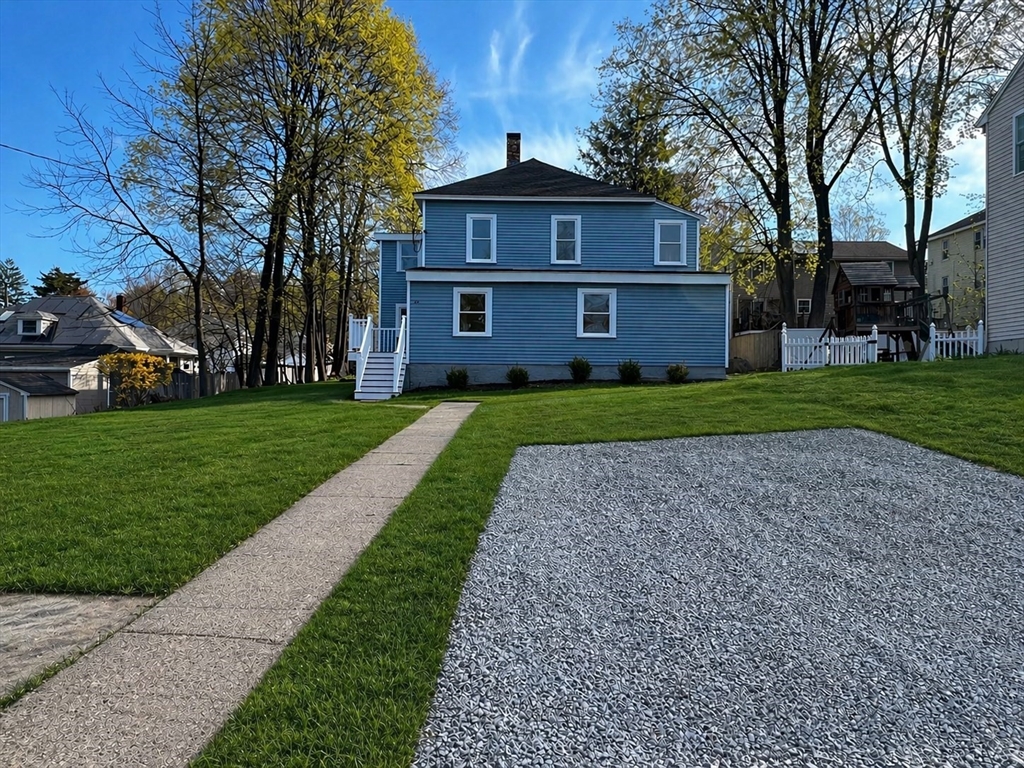 22 Douglas Avenue, Unit 1 Maynard, MA 01754 - Photo 3 of 19 a view of a big house with a big yard and large trees