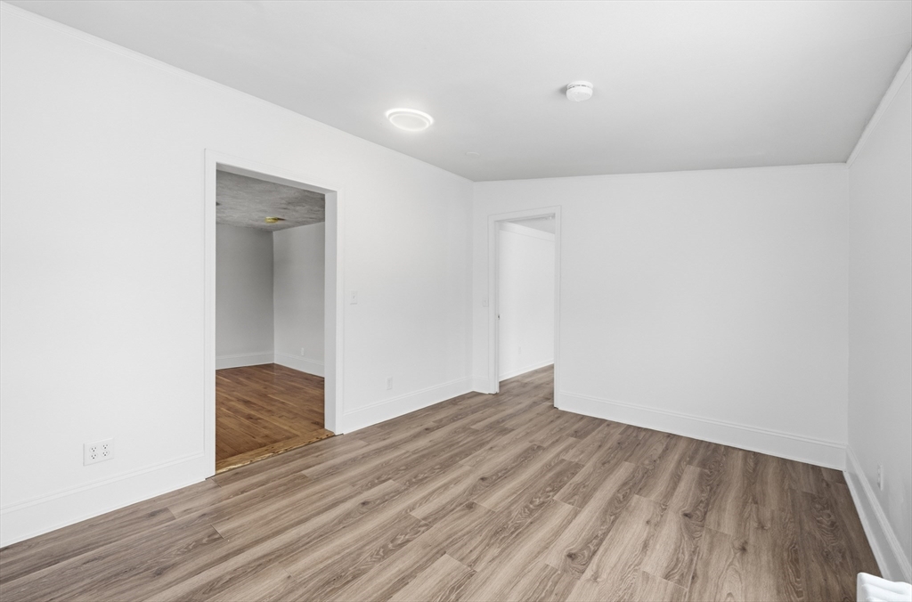 22 Douglas Avenue, Unit 1 Maynard, MA 01754 - Photo 9 of 19 a view of an empty room with wooden floor and a window