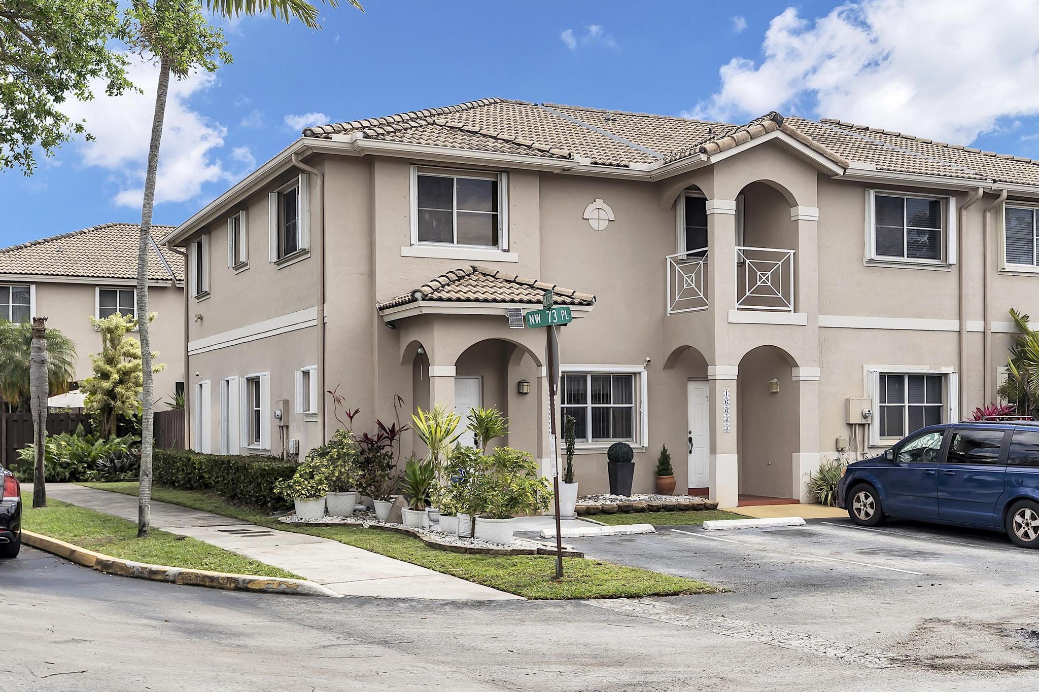 16637 Northwest 73rd Place Miami Lakes, FL 33014 - Photo 1 of 42 a front view of a house with a garden and plants