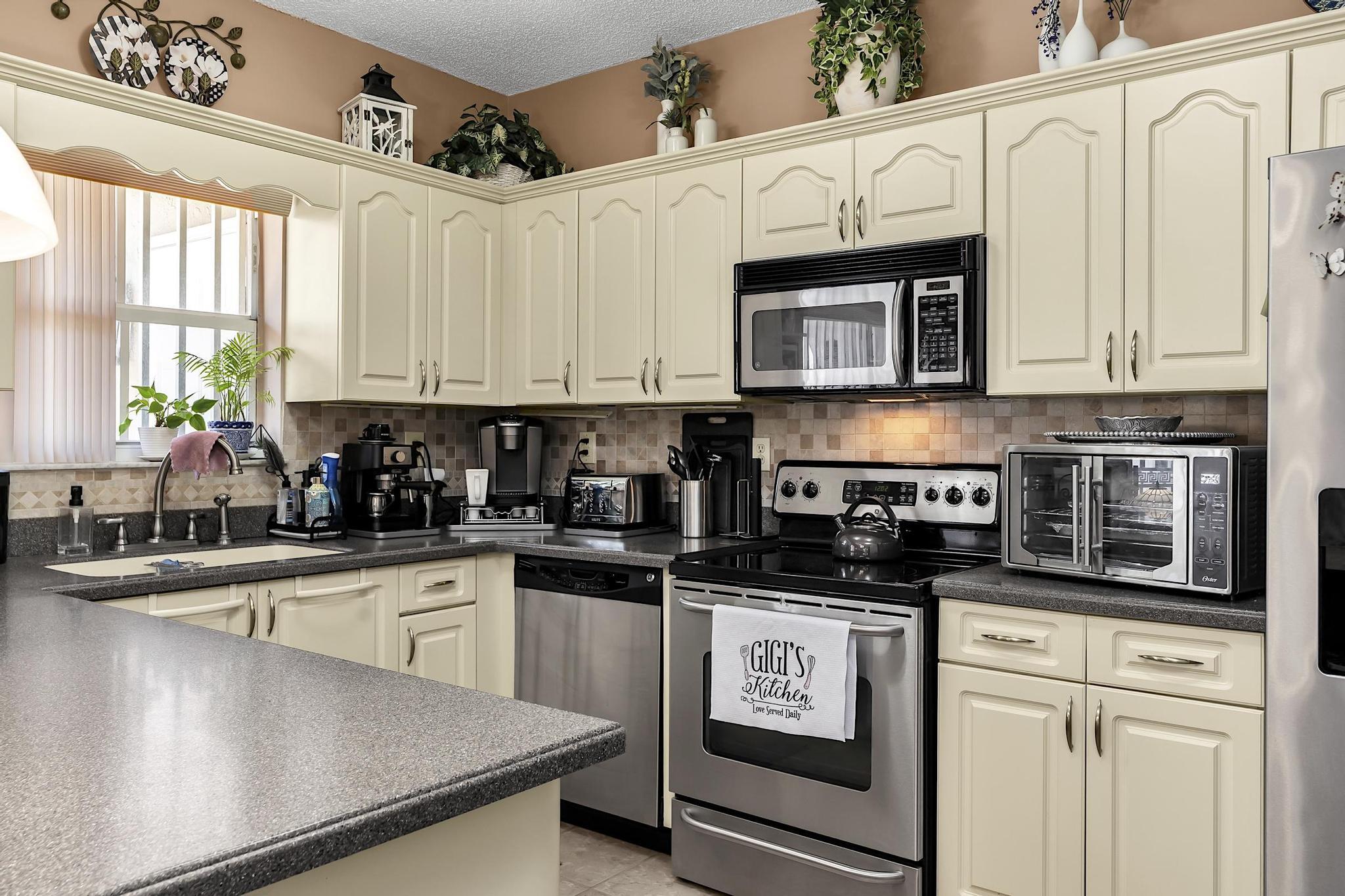 16637 Northwest 73rd Place Miami Lakes, FL 33014 - Photo 21 of 42 a kitchen with stainless steel appliances granite countertop a sink a stove and cabinets