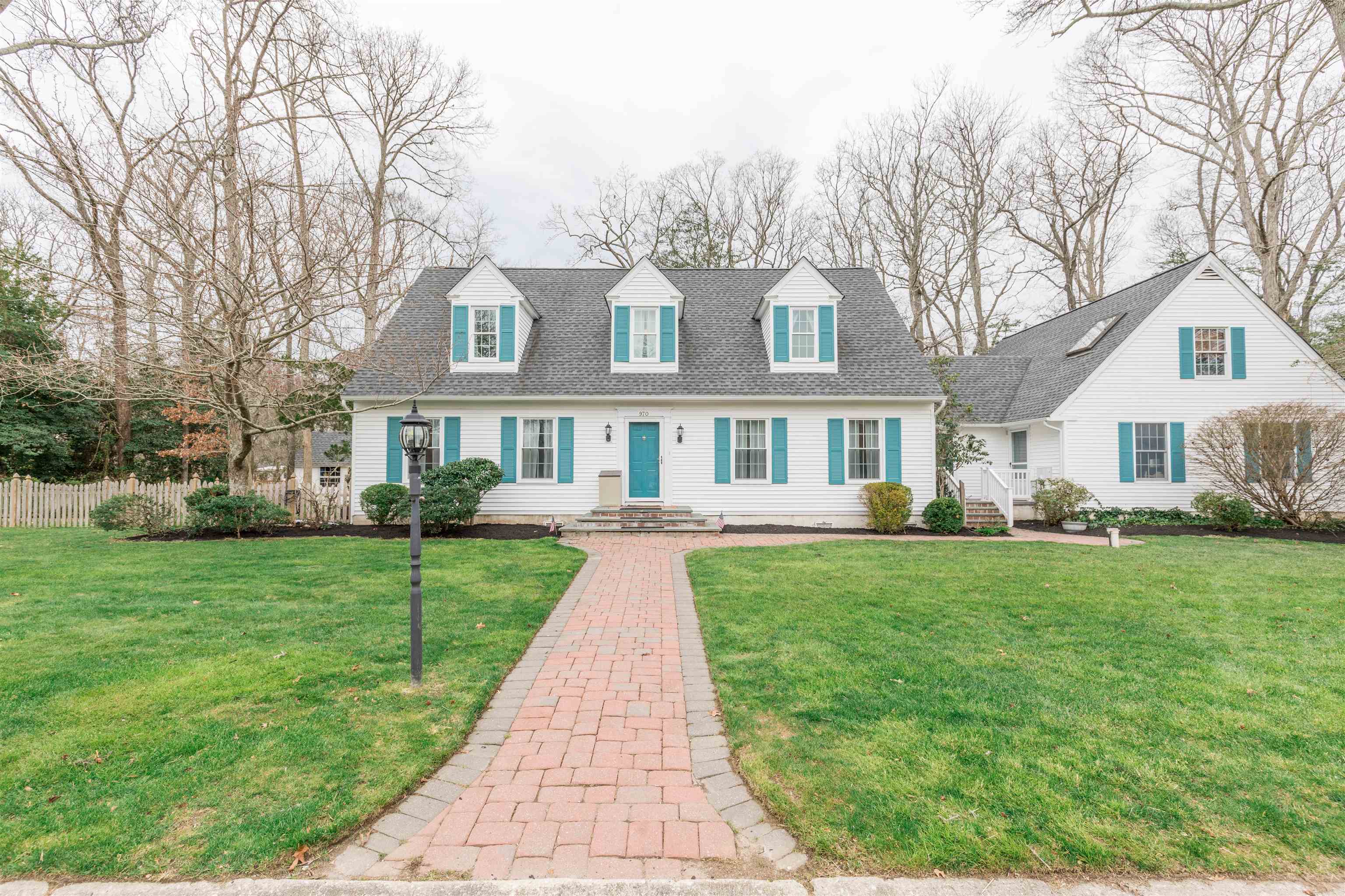 a front view of a house with a yard and trees