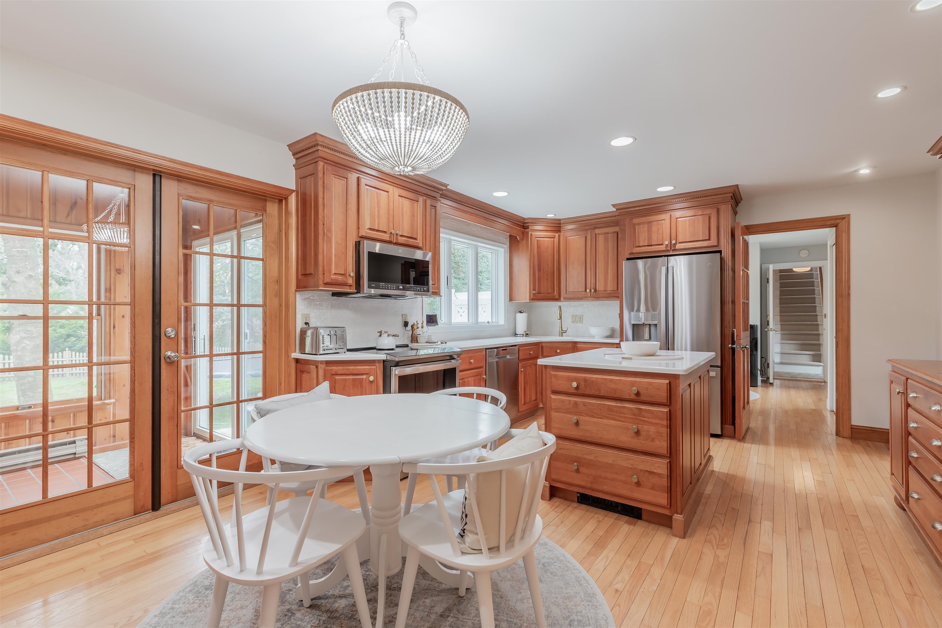 970 Tecumseh Road Erma, NJ 08204 - Photo 11 of 50 a kitchen with stainless steel appliances granite countertop a stove a refrigerator a sink a dining table and chairs with wooden floor