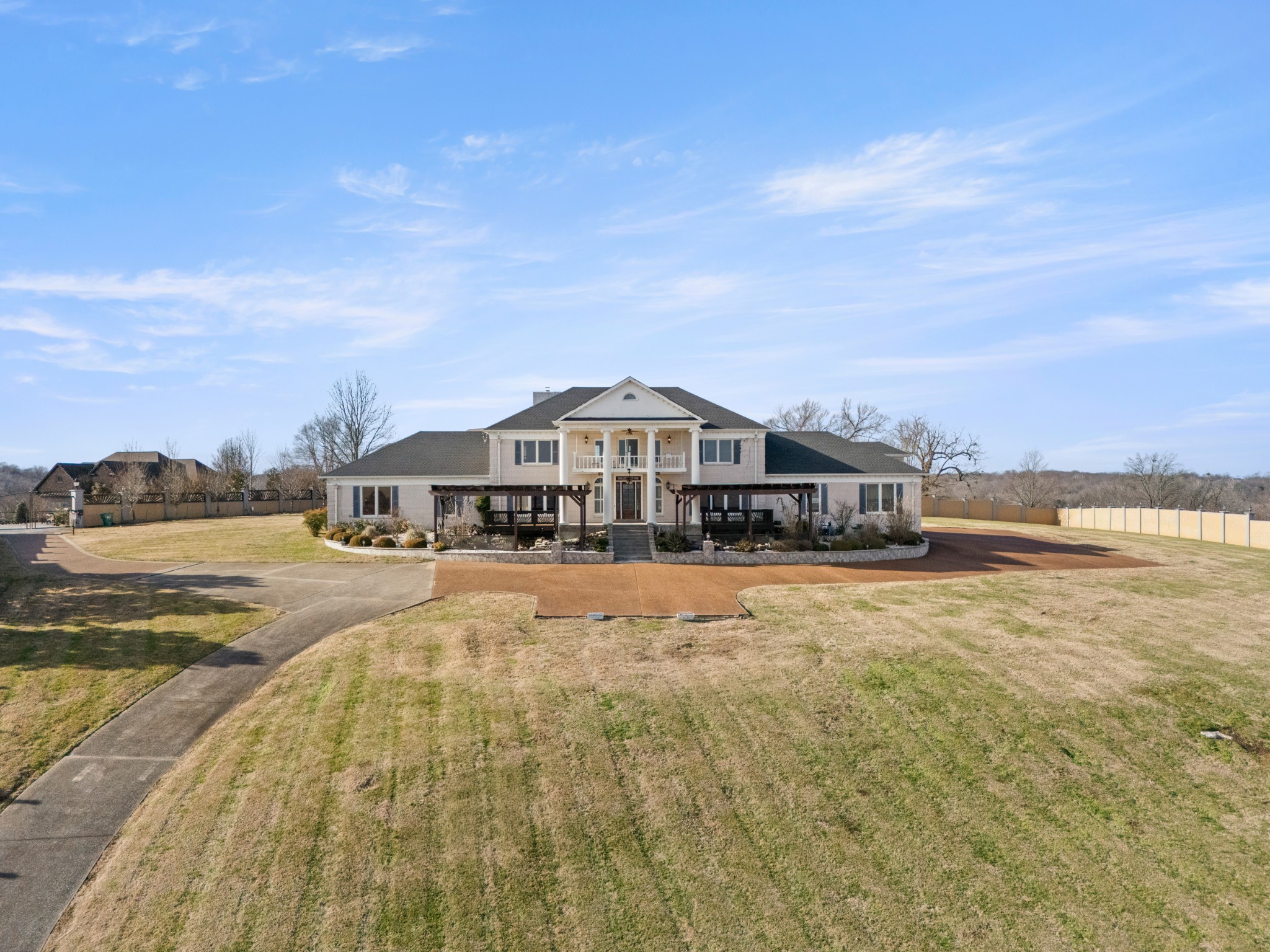 a view of a big house with a big yard and large trees