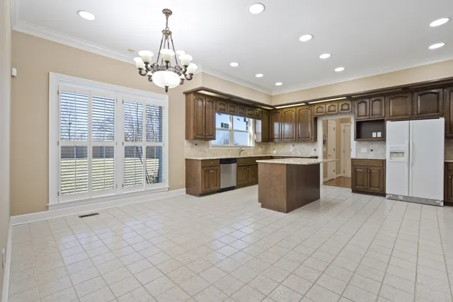 a view of dining room with kitchen island stainless steel appliances refrigerator and fireplace