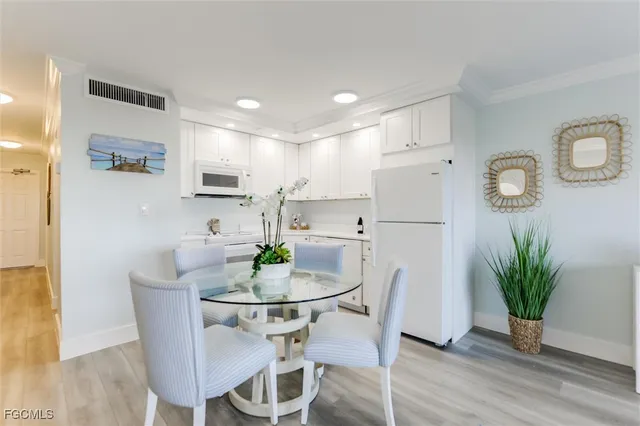 a kitchen with white cabinets and white appliances