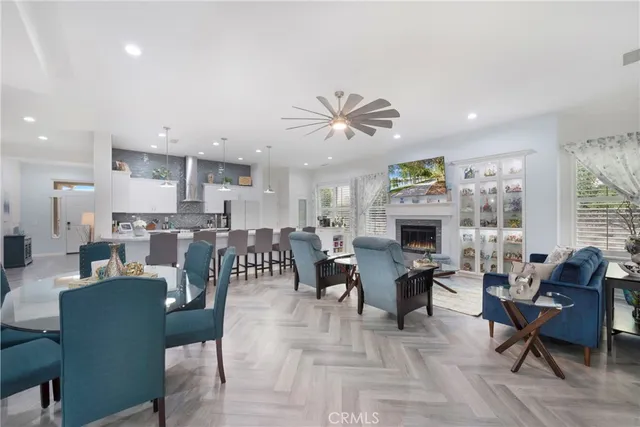 a living room with furniture a fireplace and a chandelier