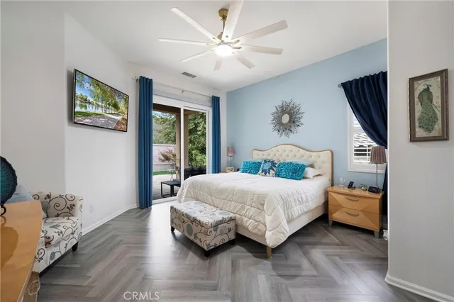 a bedroom with a bed painting on wall and a large window