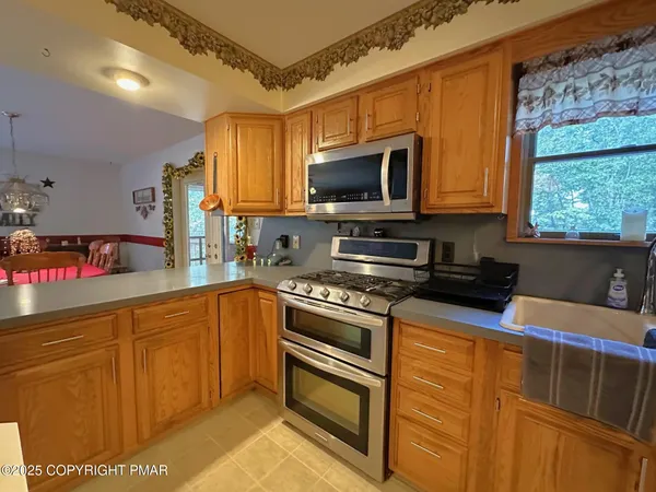 a kitchen with stainless steel appliances granite countertop a sink a stove cabinets counter space and a window