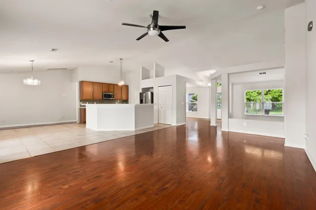 a view of a kitchen with wooden floor and a window