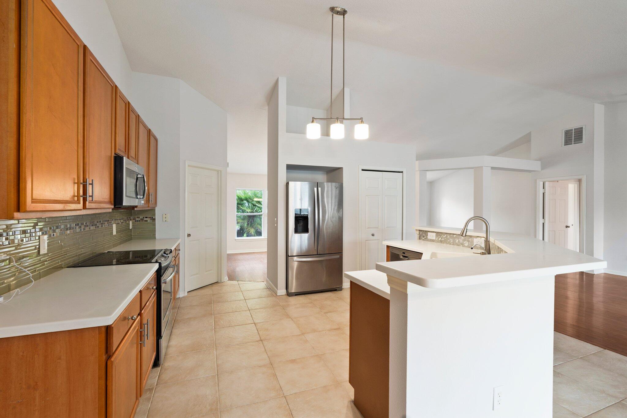 1901 Southwest Diamond Street Port St. Lucie, FL 34953 - Photo 13 of 42 a kitchen with a sink a stove a refrigerator and cabinets